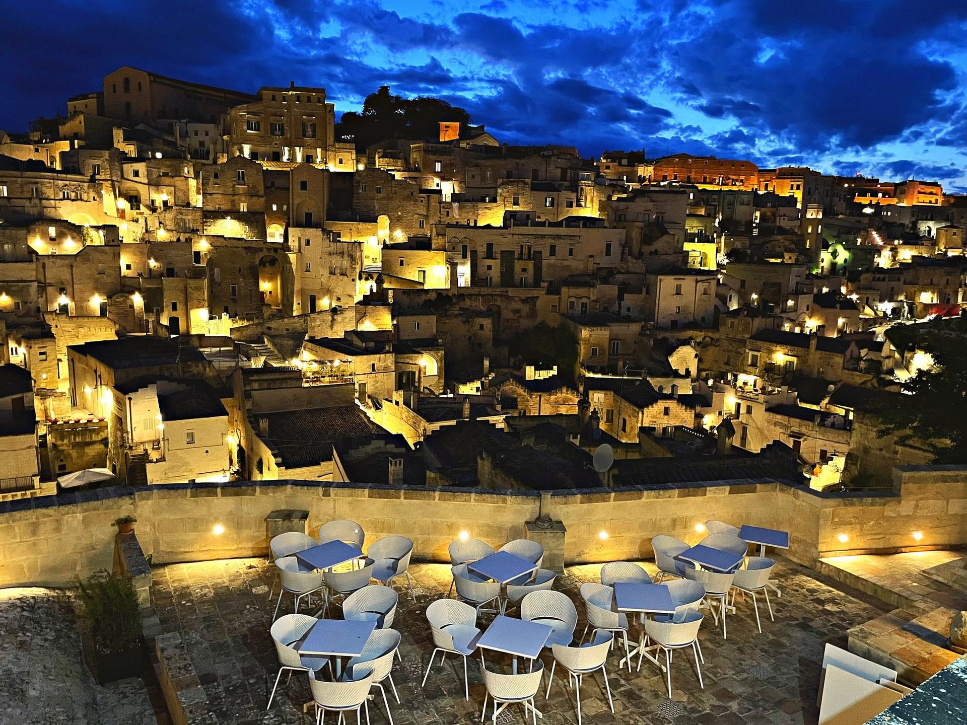 Die Panoramaterrasse von Giardini di Luce zur blauen Stunde, mit Blick auf die beleuchteten Sassi von Matera