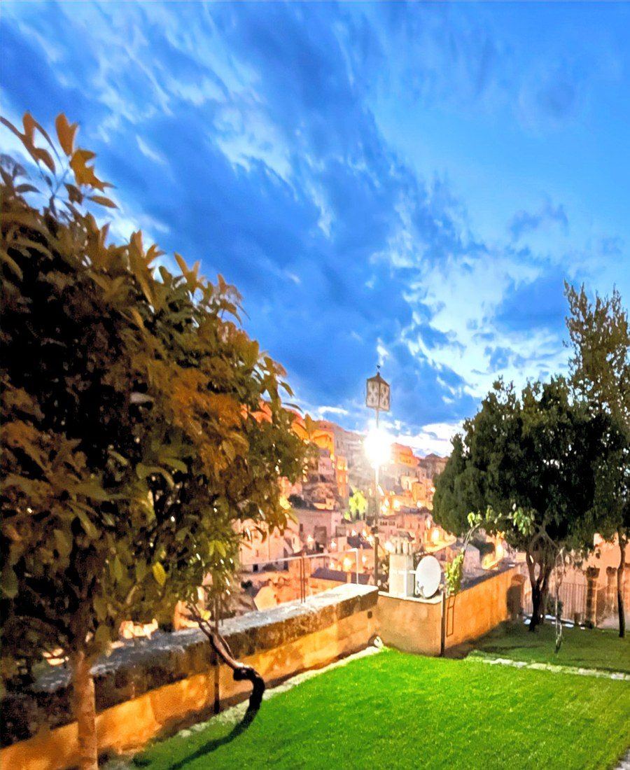 Der Gartenrasen und der freie Blick über die Sassi von Matera bei Sonnenuntergang