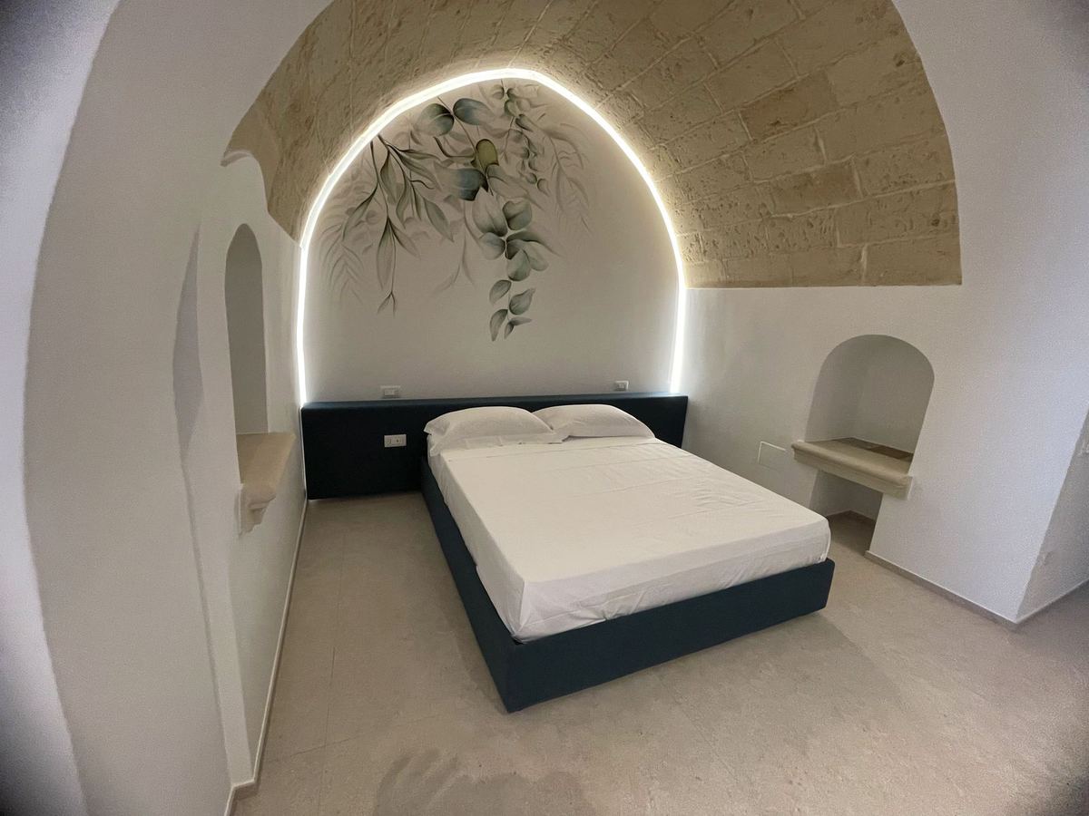 Superior Suite mit Whirlpool: Bett unter dem hinterleuchteten Bogen mit Blumendekor und Tuffgewölbe
